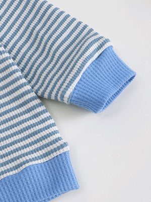 Blue and white striped children's polo shirt sleeve detail with blue cuffs and hem.