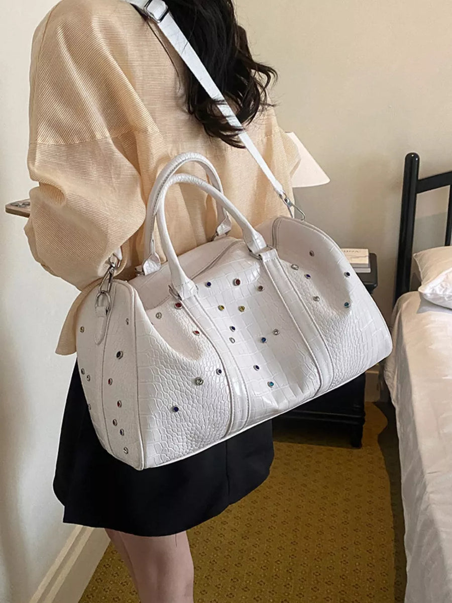 White crocodile textured duffel bag with multicolor studs and detachable strap