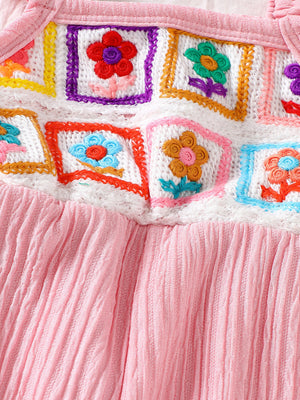 Pink baby jumpsuit with crochet floral squares and ruffle trim