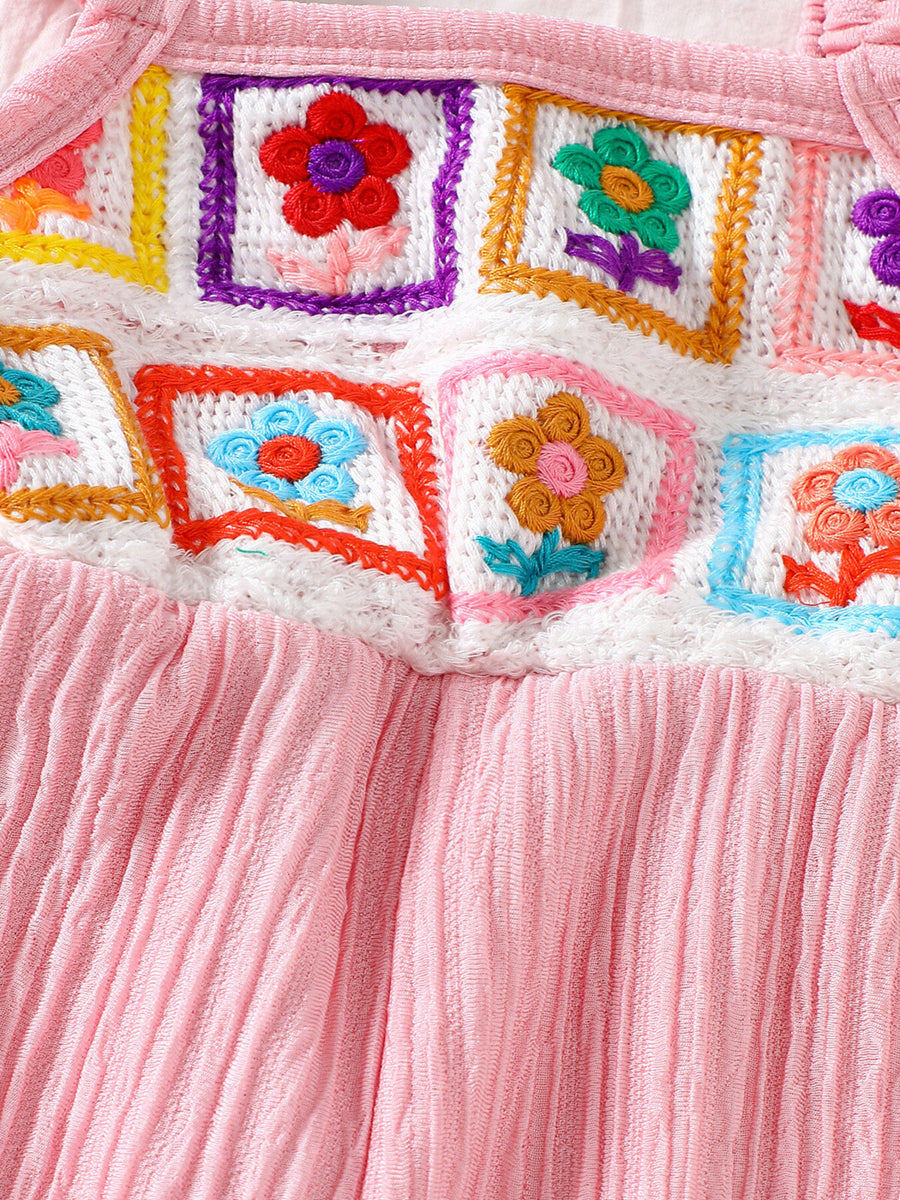 Pink baby jumpsuit with crochet floral squares and ruffle trim