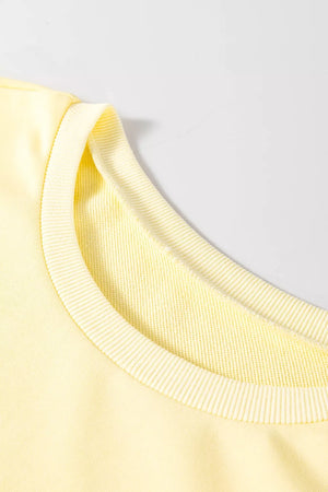 Yellow crewneck sweatshirt with ribbed trim and crew neckline.