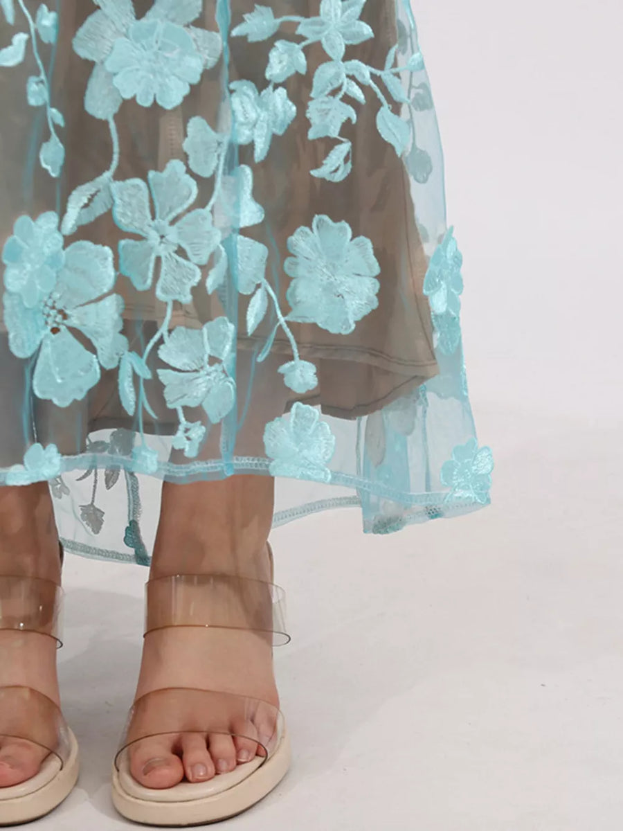 Sheer blue floral embroidered midi skirt with a beige lining.