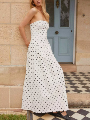 White polka dot strapless maxi dress with a fitted bodice and full skirt.