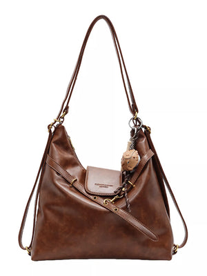 Brown convertible hobo bag made of PU leather with adjustable straps and a charm.