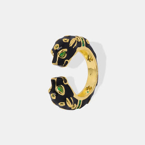 Gold panther head open ring with black enamel and green gemstone accents.