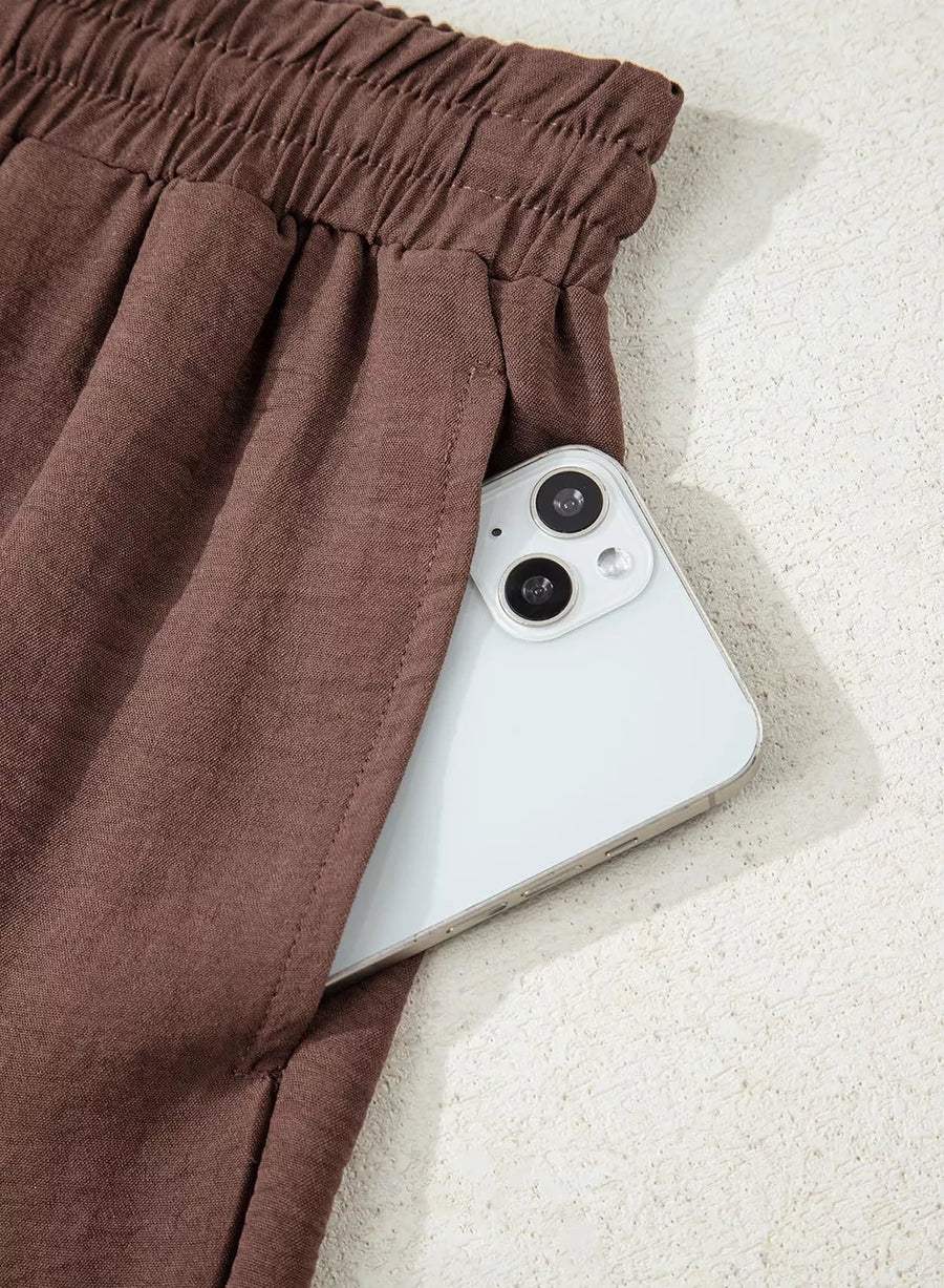 Brown maternity trousers with drawstring detail and a phone in the pocket.