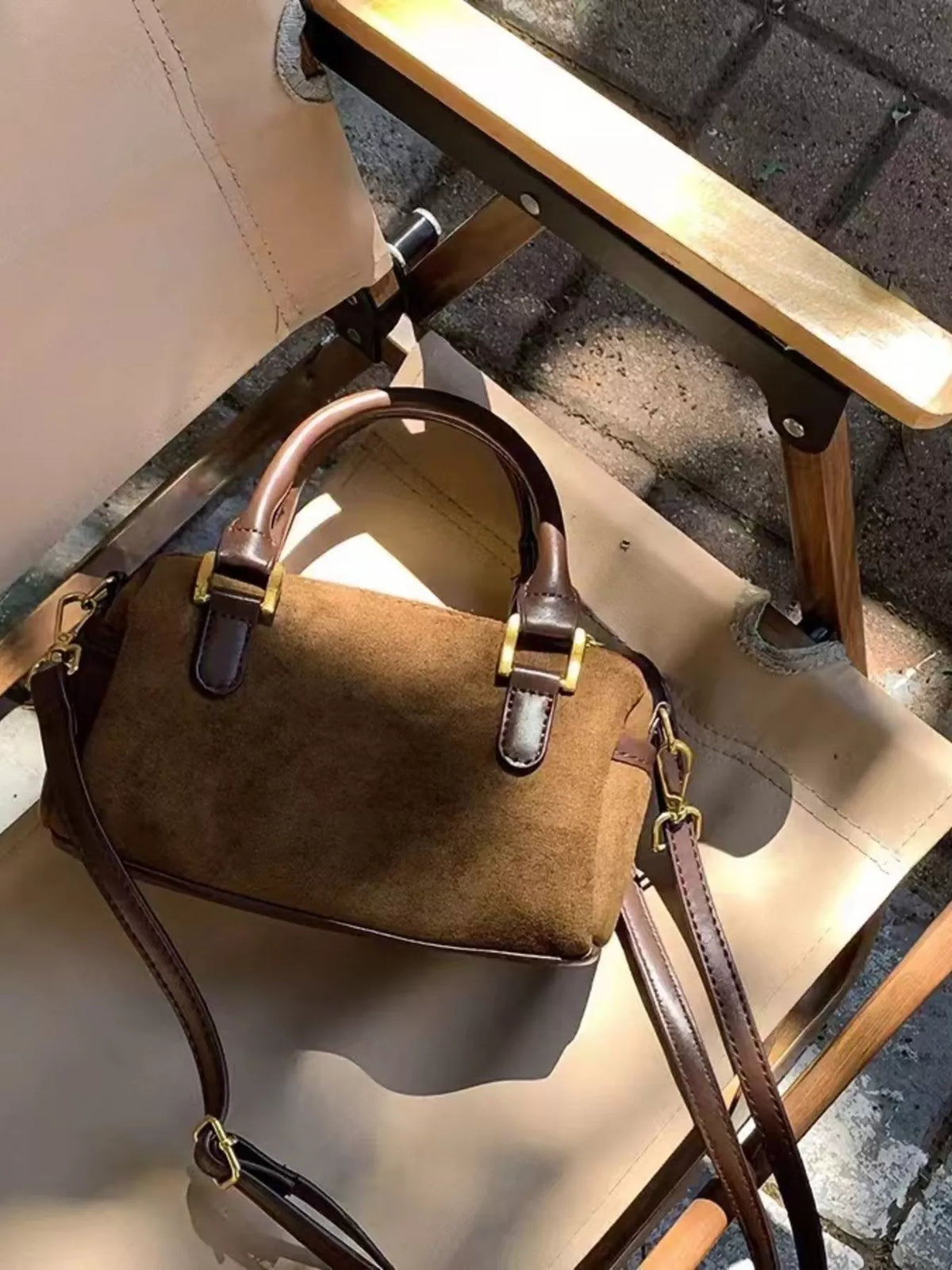 Vintage barrel crossbody bag in coffee brown suede with leather trim and gold hardware.
