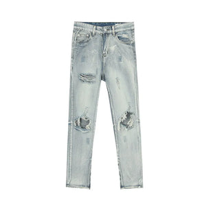 Light wash distressed skinny jeans with ankle zippers and ripped details.