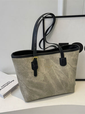Distressed pu leather tote bag in dark gray with black trim and buckle accents.