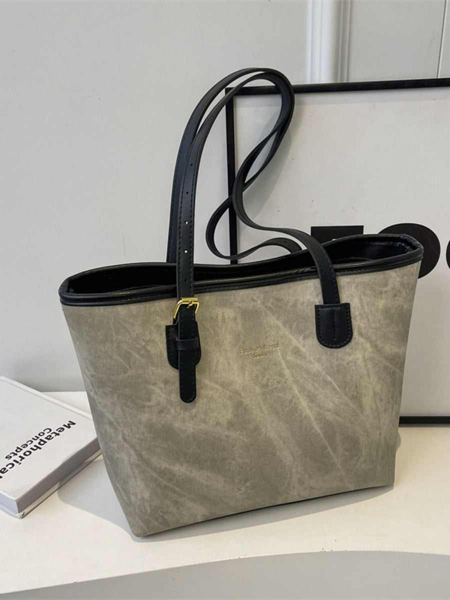 Distressed pu leather tote bag in dark gray with black trim and buckle accents.