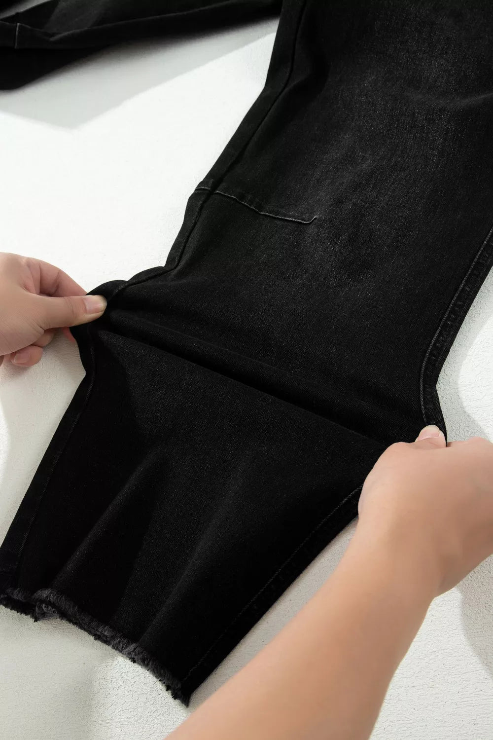 Black cotton blend cropped jeans with raw hem detail