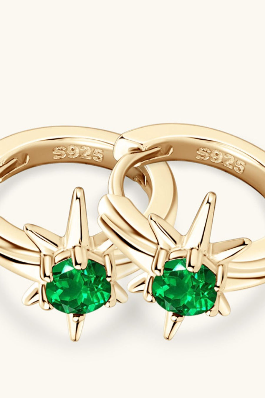 Gold starburst hoop earrings with emerald green gems and S925 marking.