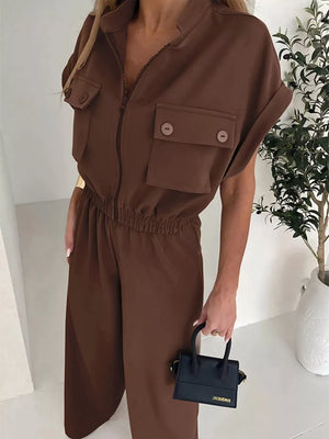 Brown utility jumpsuit with short sleeves, zip front, chest pockets and elastic waist