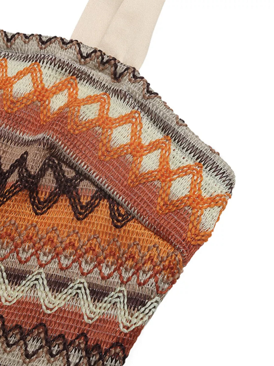 Smocked romper with zigzag pattern in orange, brown, and beige tones.