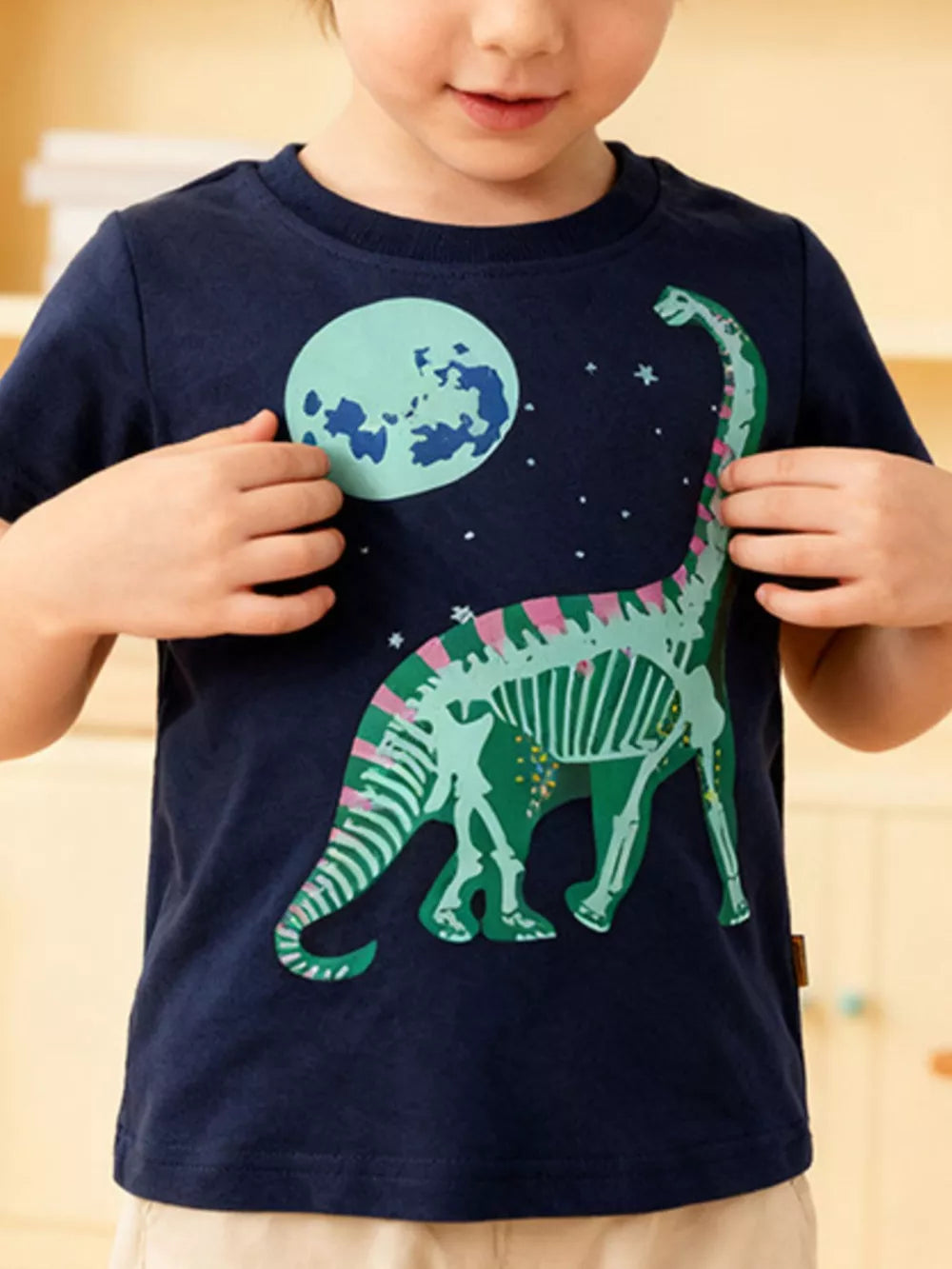 Navy cotton crew neck t-shirt with a playful green dinosaur skeleton graphic and moon.