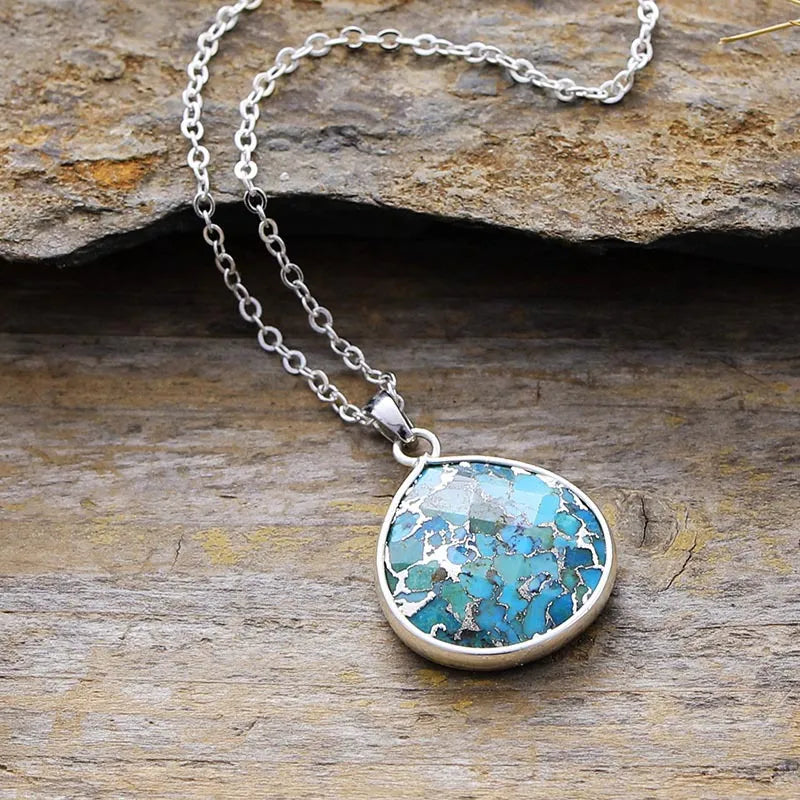 Silver-framed turquoise stone pendant necklace with a delicate chain.