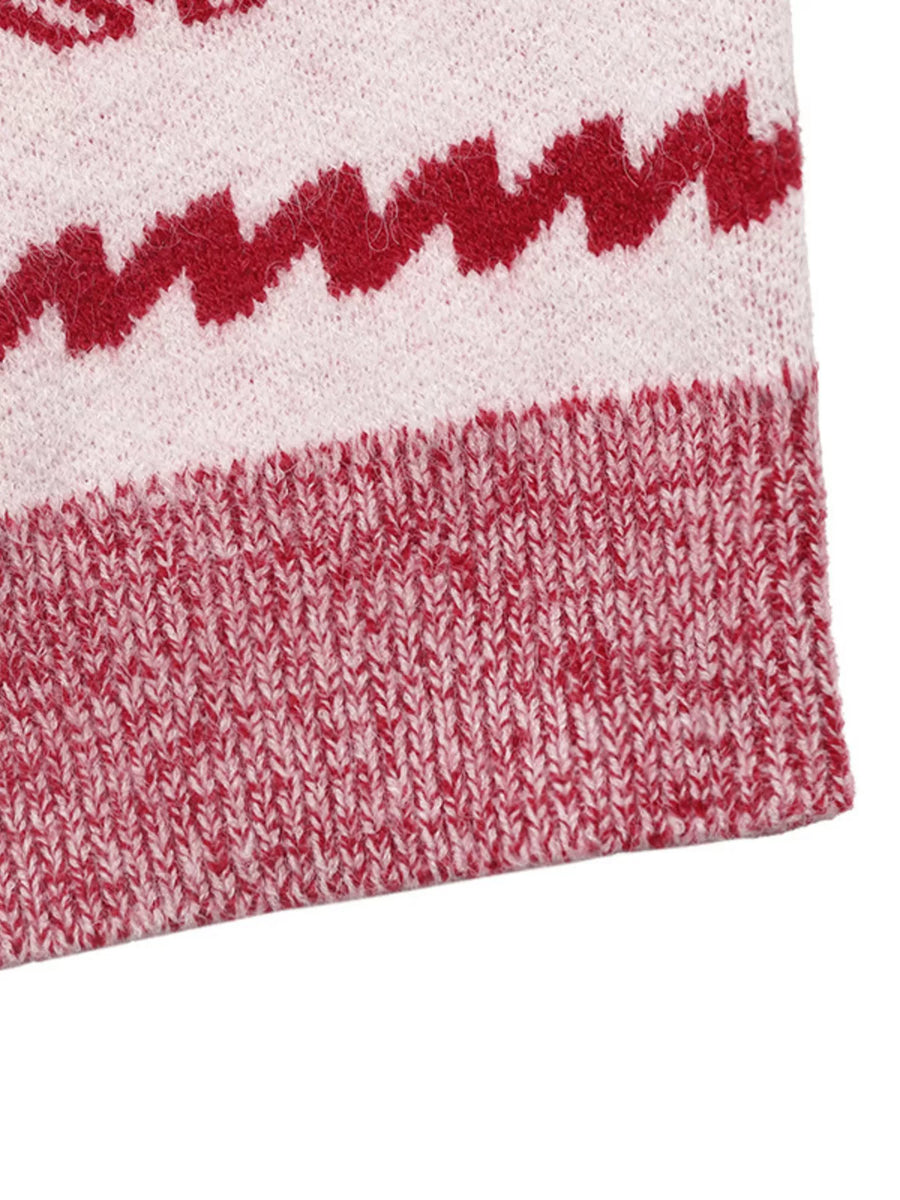 Red and white knit sweater detail with zigzag pattern and ribbed hem.