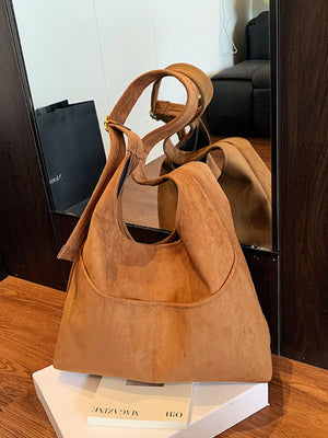 Large brown suede shoulder bag with adjustable strap and front pocket.