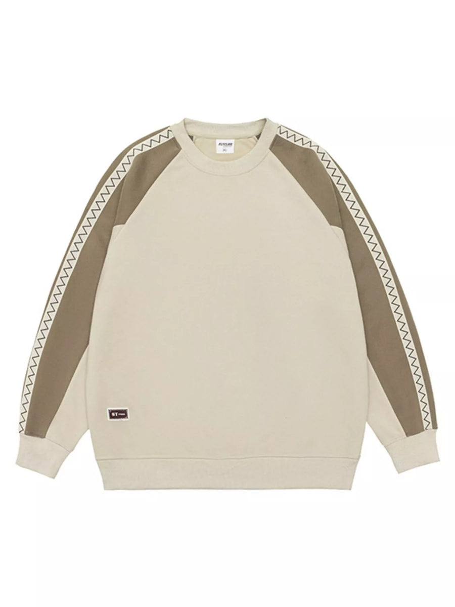 Oversized raglan sleeve sweatshirt in beige with brown sleeves featuring zigzag stitching detail.