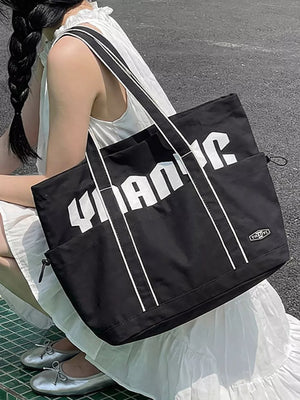 Black drawstring shoulder bag with bold white lettering and white trim.