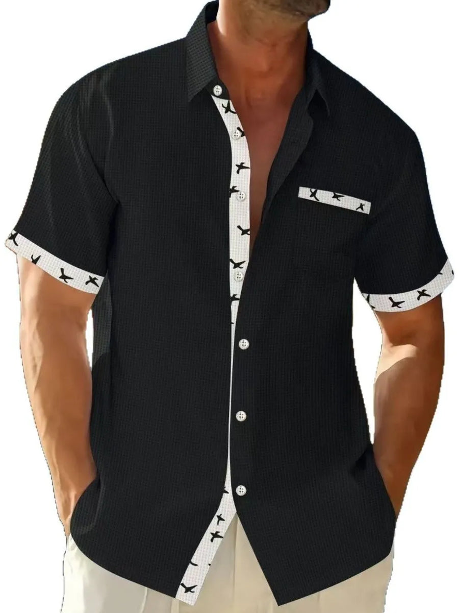 Black waffle weave short sleeve shirt with airplane print contrast trim and pocket.