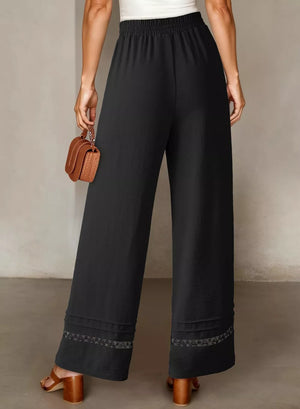 Black relaxed wide-leg maternity pants with elastic waist and decorative hem detail.