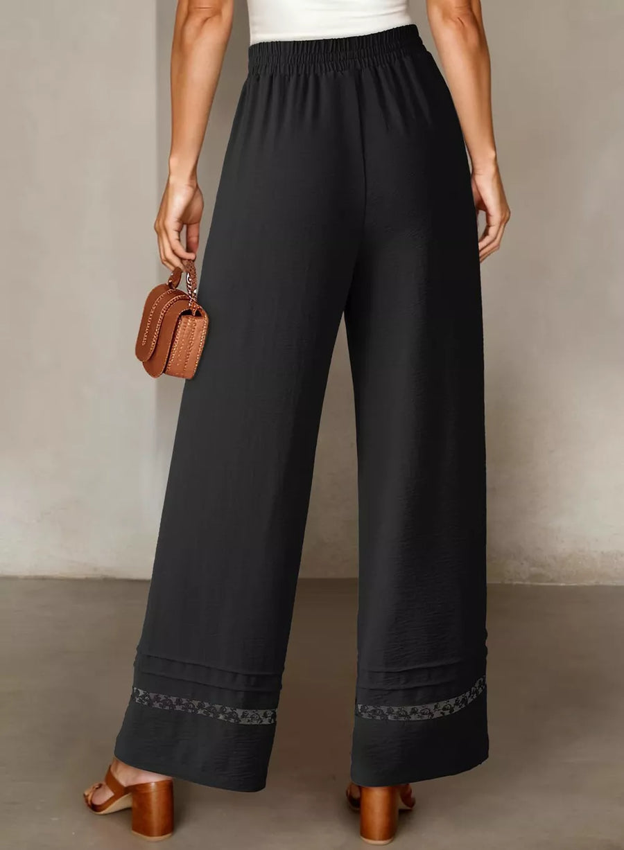 Black relaxed wide-leg maternity pants with elastic waist and decorative hem detail.