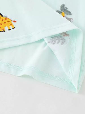Light blue baby polo shirt with embroidered giraffe and botanical details.
