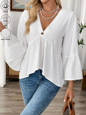 White cotton V-neck babydoll blouse with bell sleeves and a single button detail.