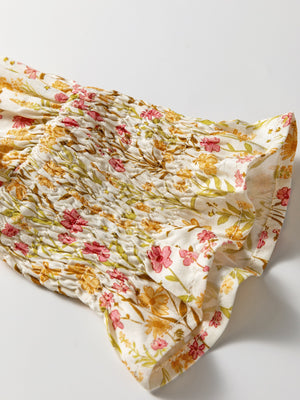 Floral print shirred sleeve dress with pink and yellow flowers on white fabric.