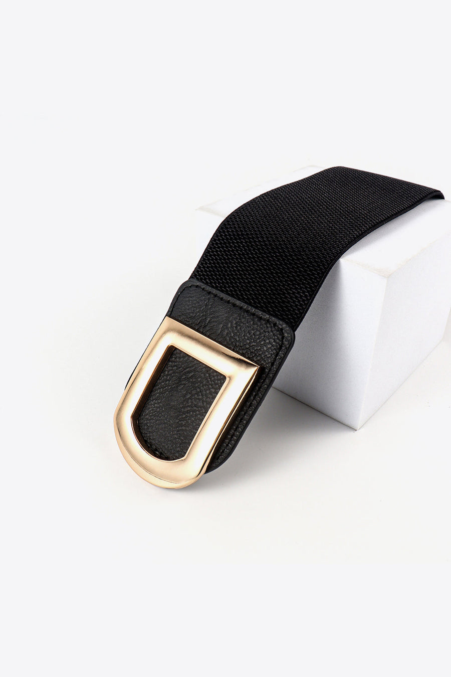 Black elastic belt with faux leather trim and gold double buckle detail.
