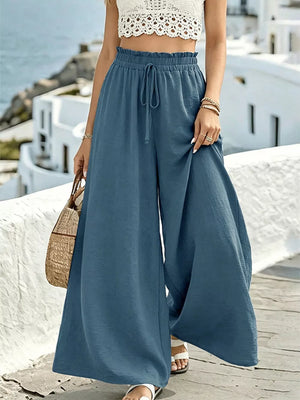 Blue wide-leg linen pants with drawstring waist and ruffled detail