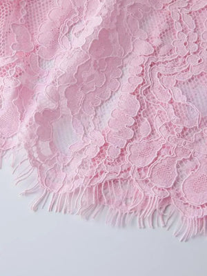 Pink lace midi dress detail with fringe hem and sheer floral pattern.