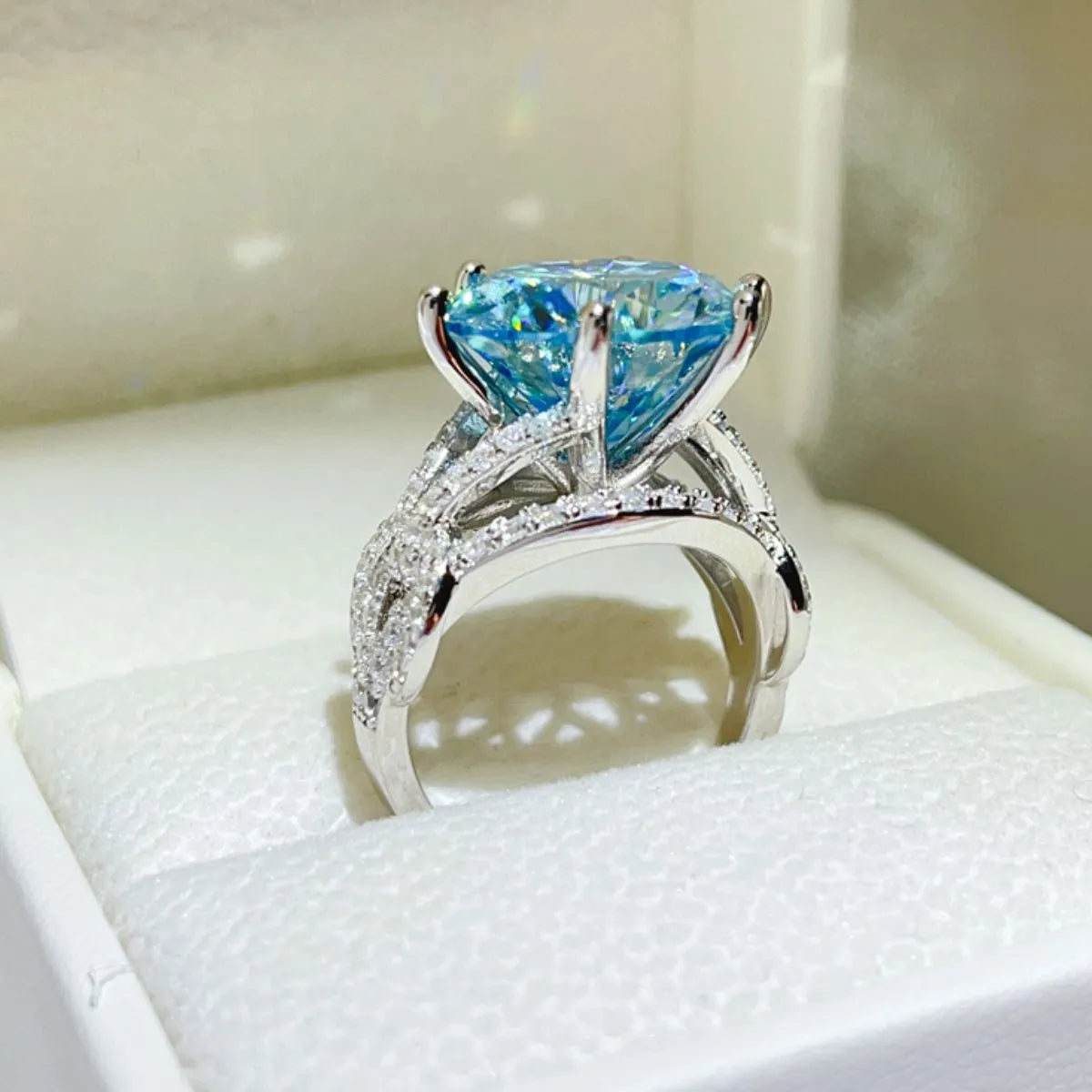 Celestial blue moissanite knot ring with pave diamond band.