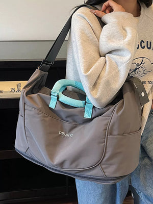 Gray Oxford cloth travel duffel bag with light blue handles and shoulder strap.