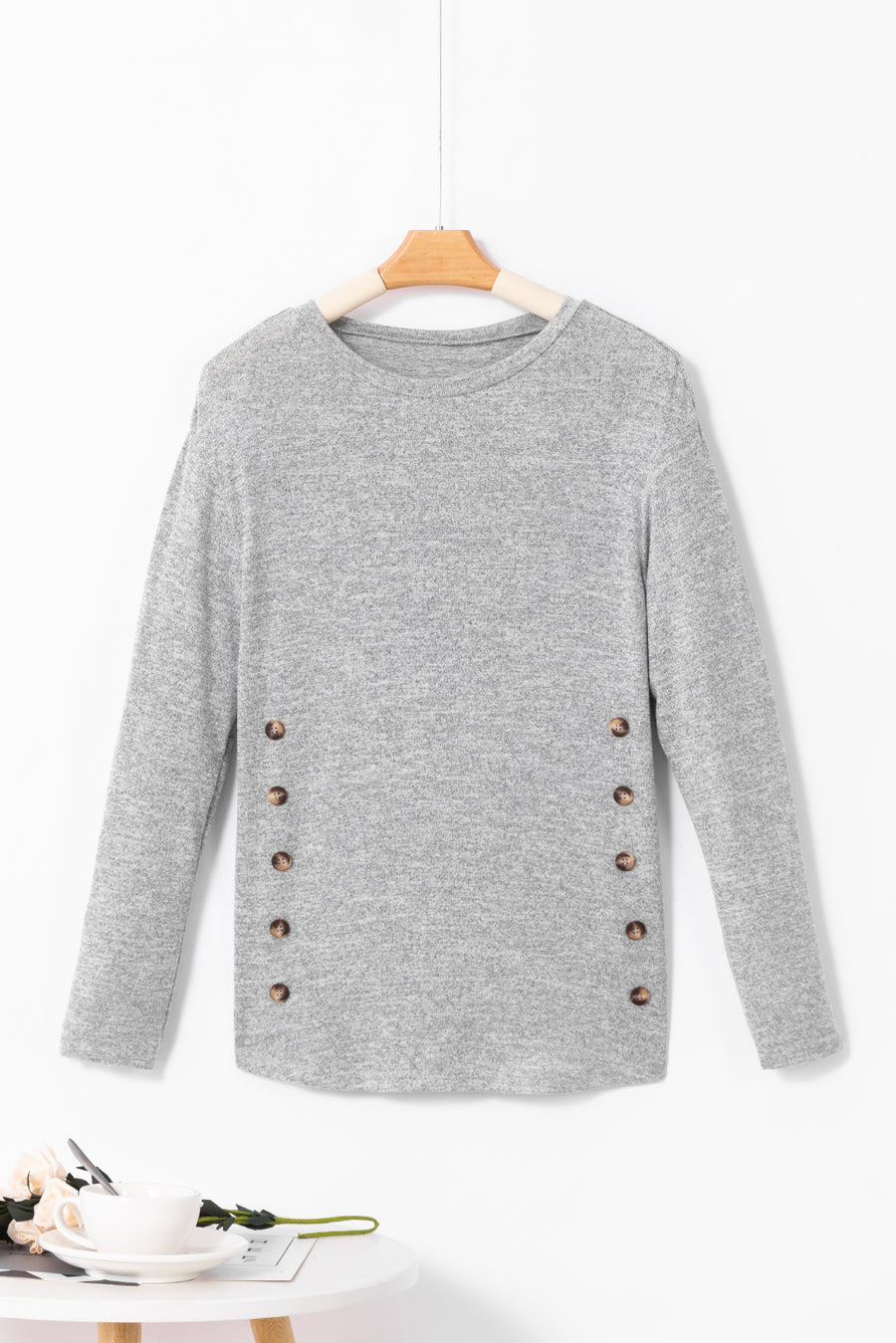 Dark gray slouchy knit top with side button details and long sleeves.