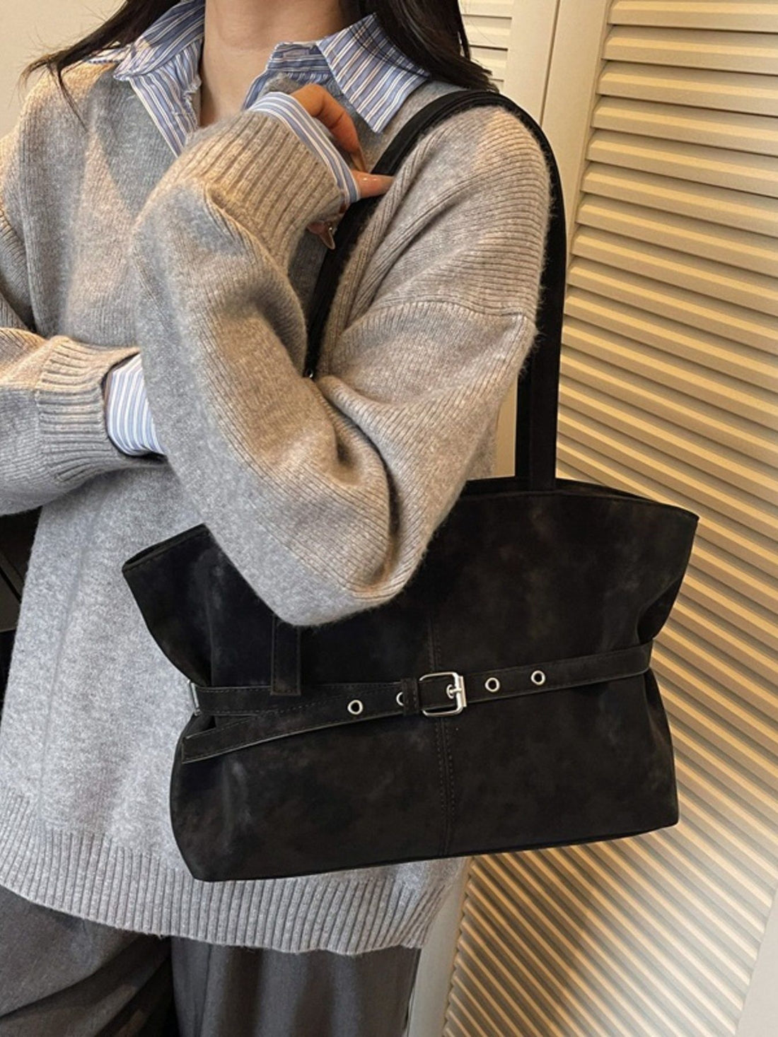 shoulder bag in black featuring buckle detail and structured fit
