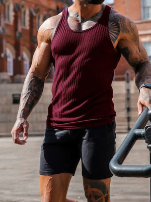 Burgundy ribbed muscle tank top with scoop neck, worn by a man with tattoos.