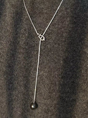 Lustrous pearl drop Y-necklace in dark gray with a delicate chain and horseshoe clasp.