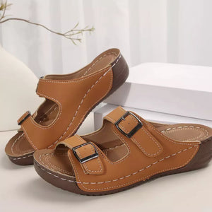 Dark brown dual buckle mid-wedge sandals with white stitching and adjustable straps.