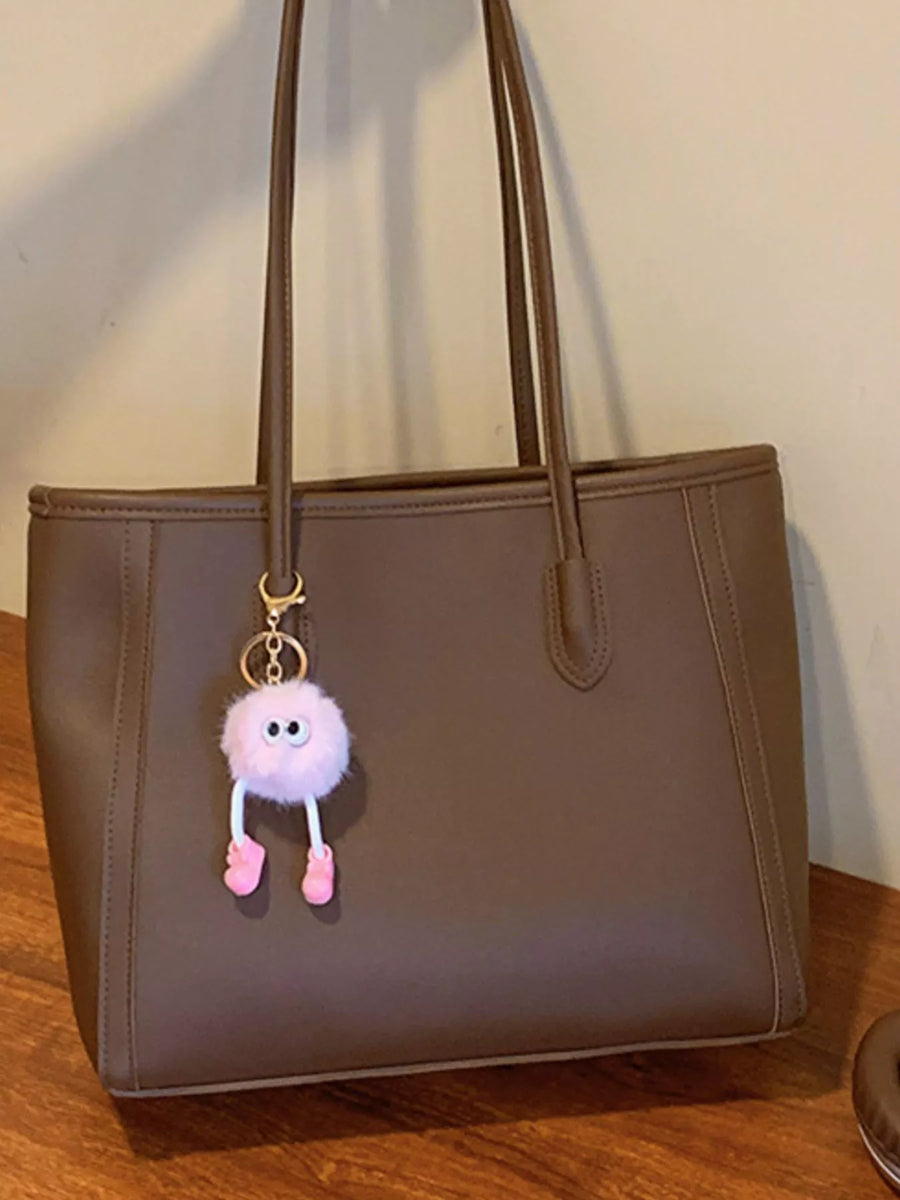 Brown PU leather tote bag with a pink fluffy charm and pink shoes.