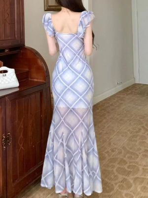 Blue plaid ruched bodycon maxi dress with ruffled cap sleeves and a flared hem.