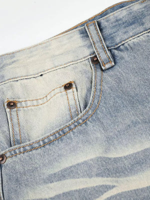 Men's vintage wash wide leg jeans in light blue denim with distressed details and copper rivets.