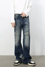 Distressed flare denim jeans in medium wash with raw edge finish and ripped details.