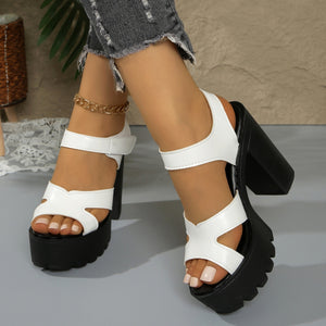 White open-toe sandals with black chunky block heel and platform sole.
