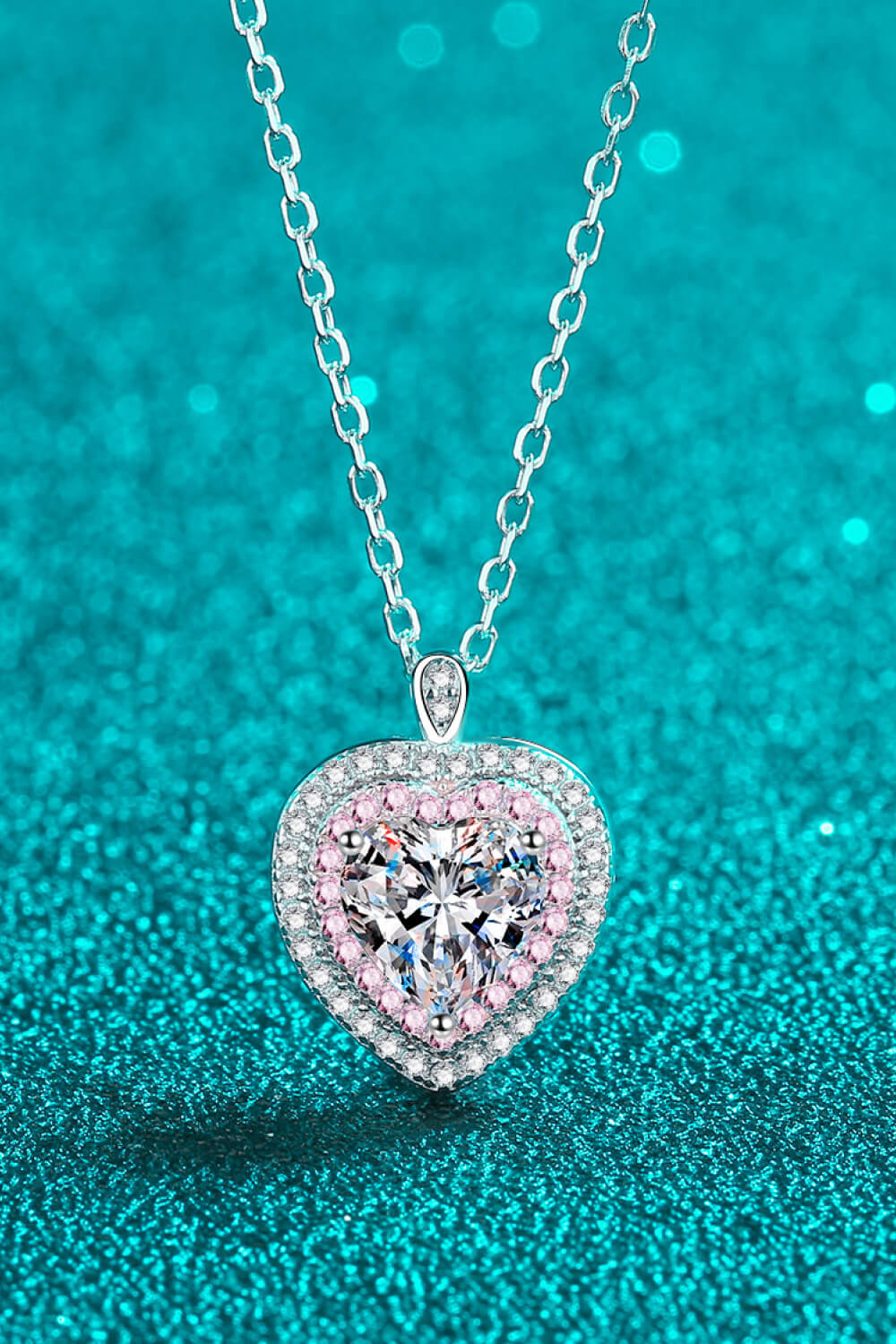Silver heart halo moissanite pendant necklace with pink accent stones.