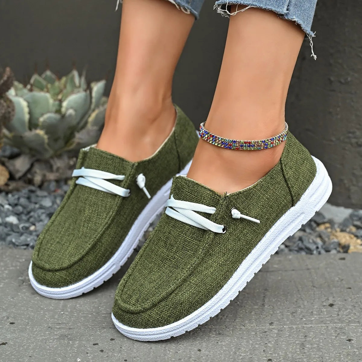Army green linen-blend boat shoes with white laces and contrast sole.