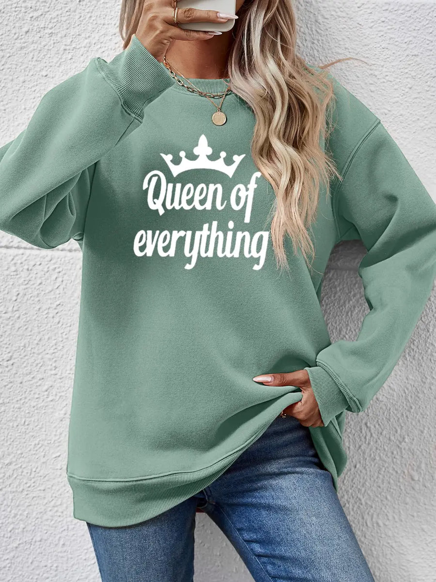 Sage green graphic sweatshirt with white "Queen of everything" text and crown detail.