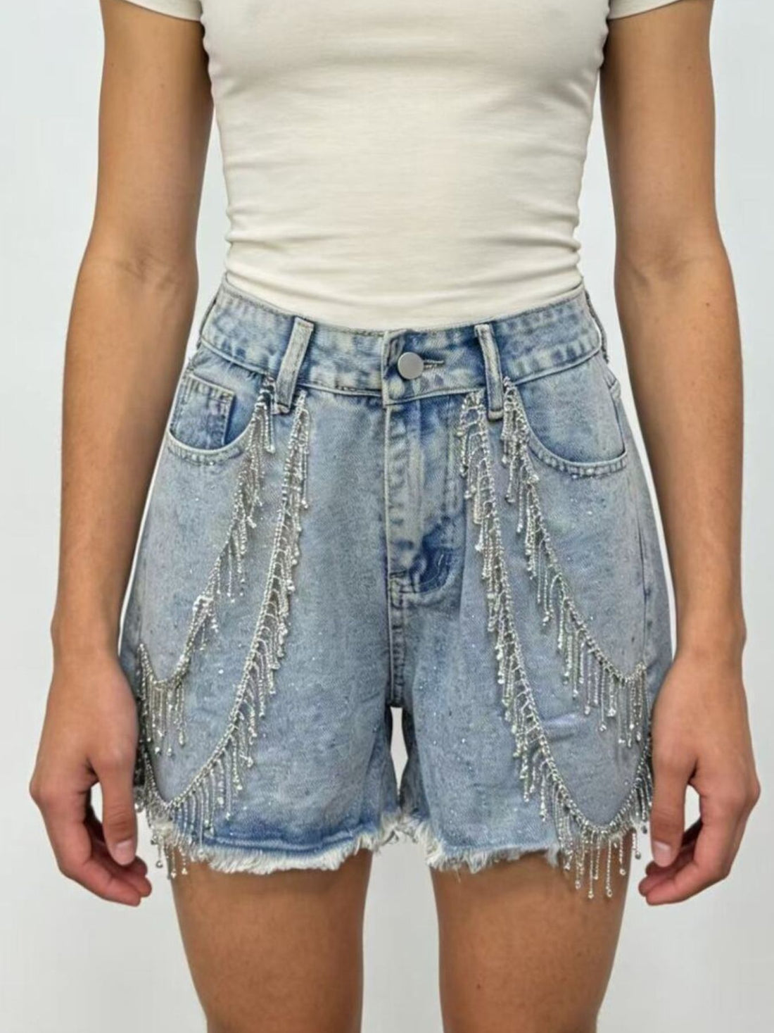Sky blue denim shorts with rhinestone chain embellishments and frayed hem