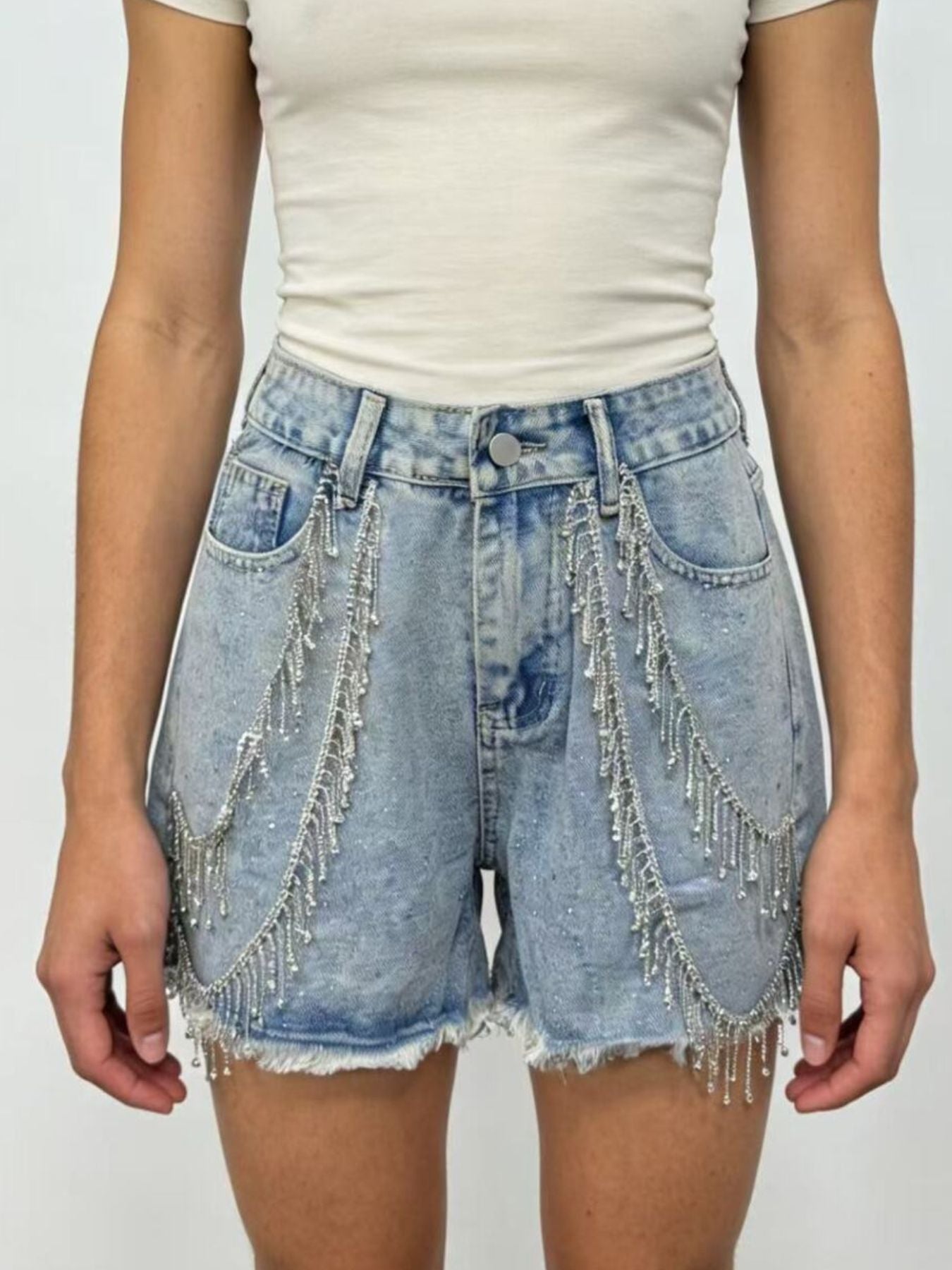 Sky blue denim shorts with rhinestone chain embellishments and frayed hem